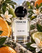 An ALLURE VIVE fragrance bottle with a round black cap, surrounded by orange slices, lime halves, and white blossoms on rocks.