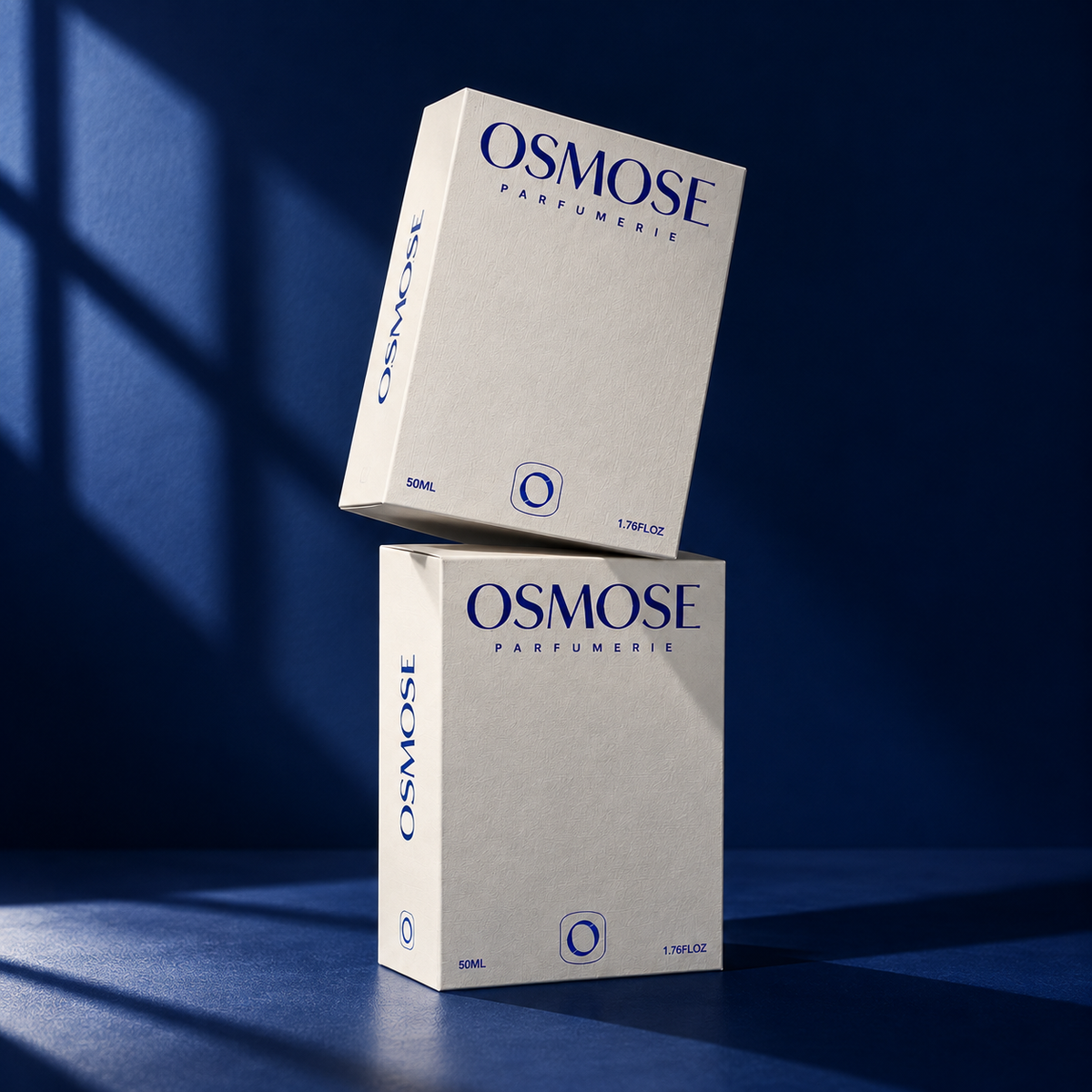 Two stacked rectangular boxes for L’AIMANT eau de parfum, with dark blue text reading OSMOSE PARFUMERIE and 50ML / 1.76FLOZ.